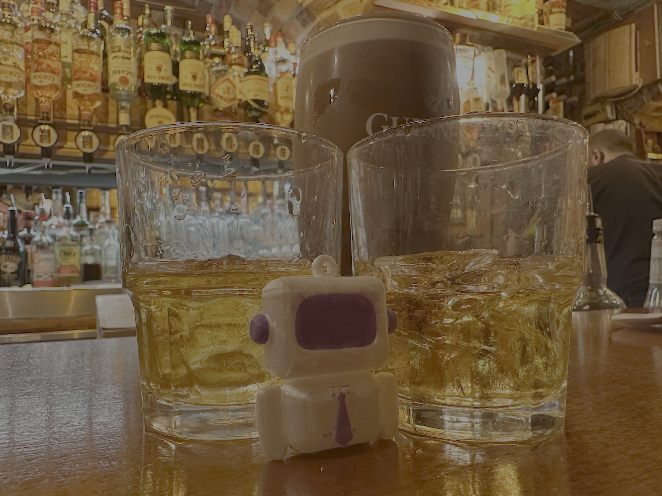 Arty between two whiskey tumblers and a pint
