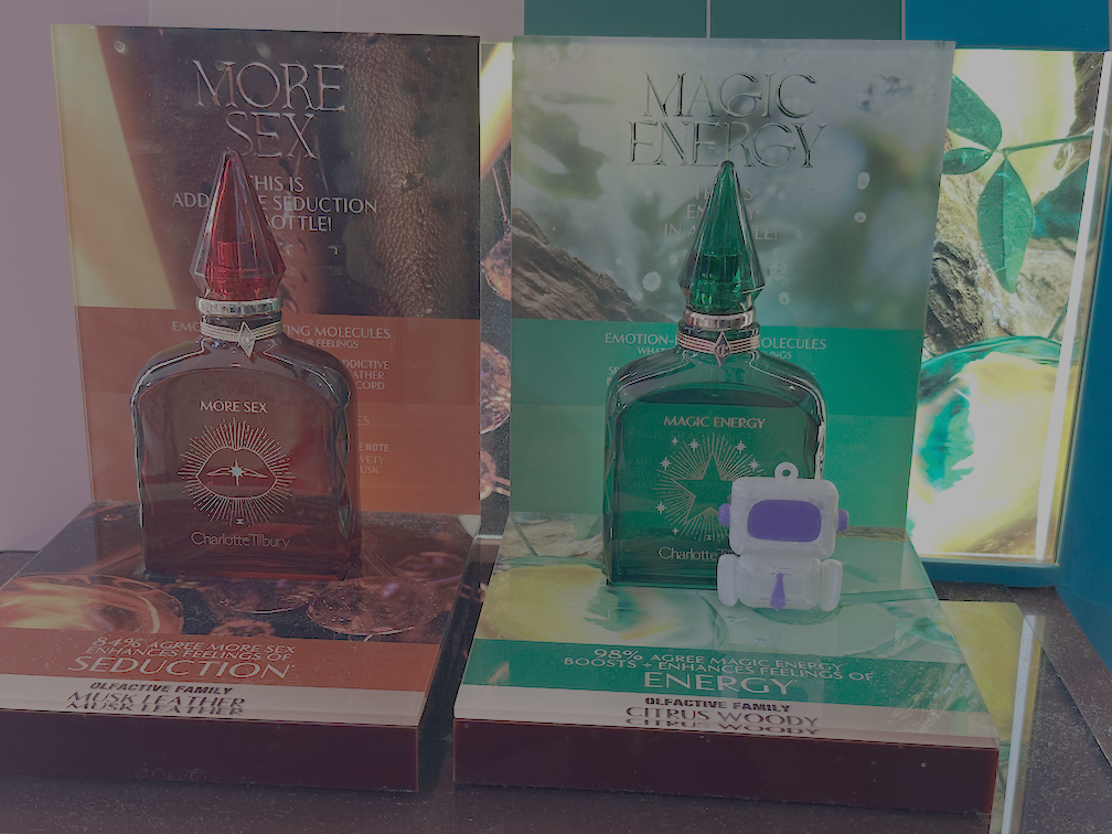 Arty beside colourful fragrance bottles with Magic Energy branding behind